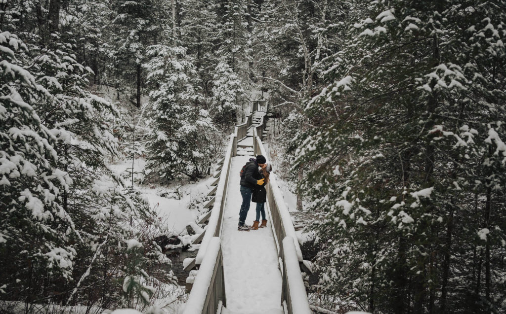 Couple kissing on a bridge during winter